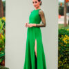 Vestido largo verde esmeralda con abertura abotonada en la falda y aplicaciones en los hombros.